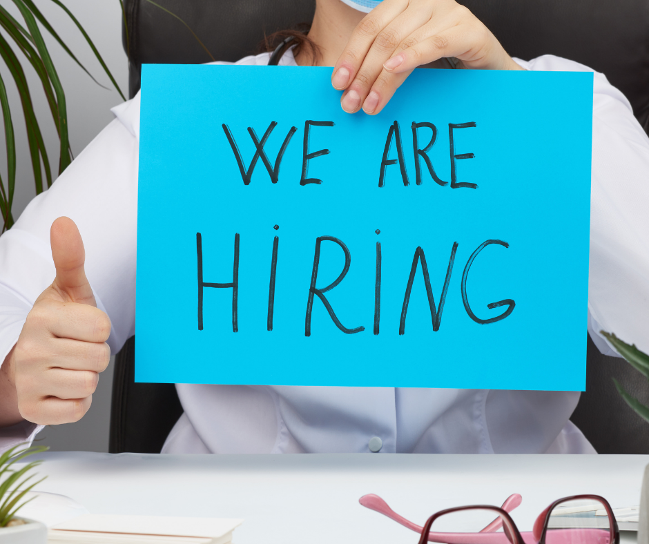 We Are Hiring person holding paper with "We Are Hiring" written on it