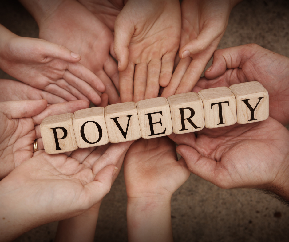 Many hands holding blocks that spell out the word poverty