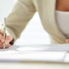 A person sitting down to sign a letter