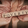 Many hands holding blocks that spell out the word poverty