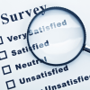 A magnifying glass highlighting a survey question of very satisfied, satisfied, neutral, unsatisfied.